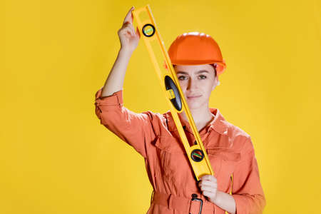 Female builder on yellow background.の写真素材
