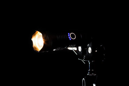 Flashlight and beam of light on a black background.