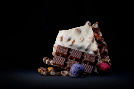 Chocolate bar, crushed pieces of dark chocolate and nuts. Praline Chocolate sweets.