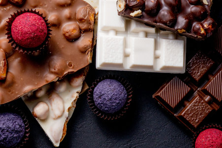 Chocolate bar, crushed pieces of dark chocolate and nuts. Praline Chocolate sweets.