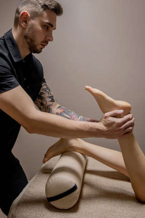 Close-up of female hands doing foot massage. Woman enjoyingreflexology foot massage in wellness spa.の写真素材