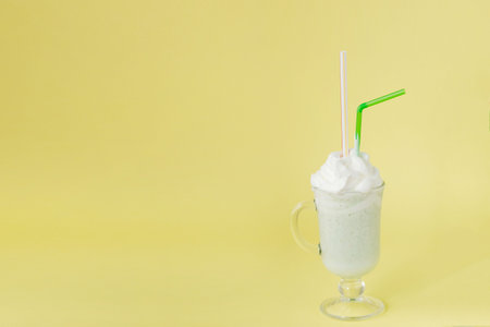 Cold green Peppermint milkshake on a yellow backgroundの写真素材
