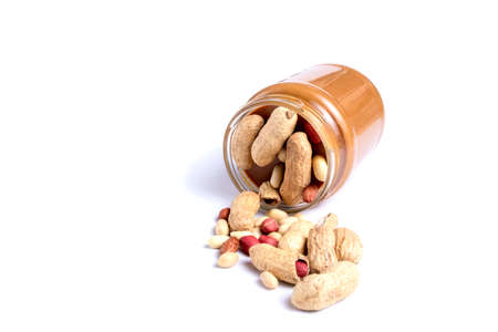 Peanut butter isolated and peanuts in the peel scattered on the white background. Copy spaceの写真素材