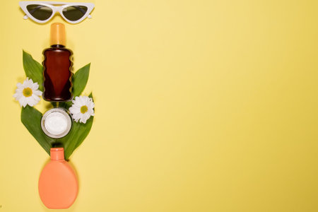 Cosmetics SPF for face and body on yellow background. Top view, flat lay.