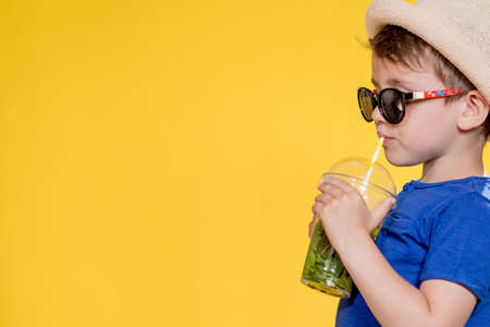 Summer refreshment. Cold beverage. Little boy with plastic cup of fresh lemonade.の写真素材
