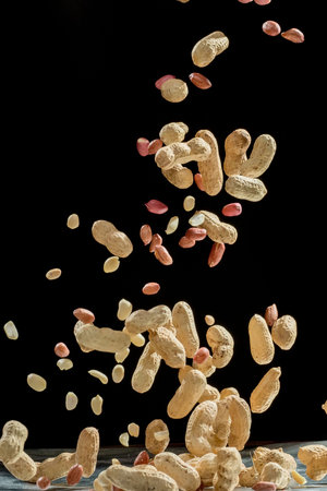 Realistic freeze motion of flying peanuts on black background.の写真素材
