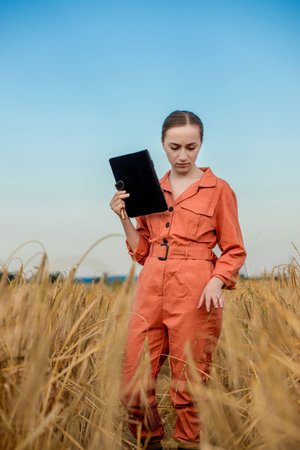 Woman caucasian technologist agronomist with tablet computer in the field of wheat checking quality...