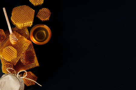 Jar of honey with honeycomb on black table, top view. space for text.の写真素材