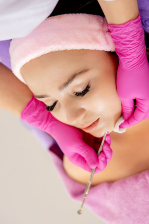 Cosmetologist at spa beauty salon doing acne treatment using mechanical instrument. Concept of...
