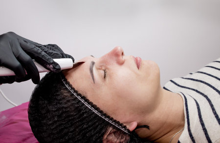 Young woman receiving ultrasound cavitation facial peeling cleansing. Cosmetology facial skin care...
