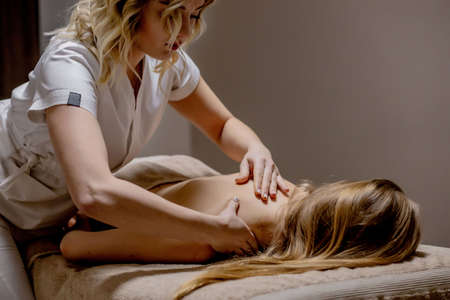 Body care. Young girl having massage, relaxing in spa salon, closeupの写真素材