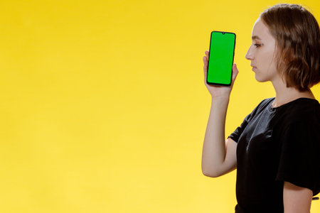 Happy female showing smartphone with green screen, social network app.