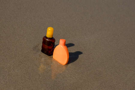 Closeup of sunscreen protection set on sandy beach at tropical seaside on warm sunny day. Skin care conceptの写真素材
