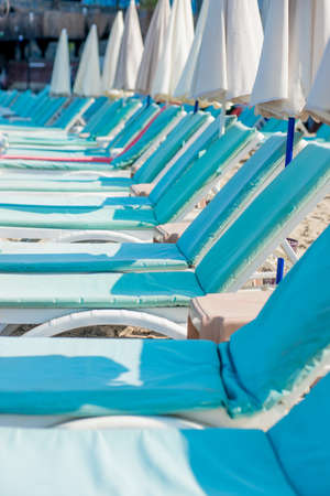 Empty blue sunbeds on a modern beach.の写真素材