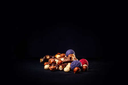 Chocolate bar, crushed pieces of dark chocolate and nuts. Praline Chocolate sweets. Copy space.の写真素材