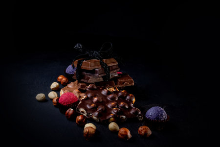 Chocolate bar, crushed pieces of dark chocolate and nuts. Praline Chocolate sweets.の写真素材