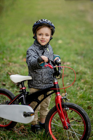 Portrait of smiling boy in a helmet with a bicycle in the park.の写真素材
