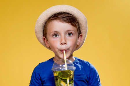 Portrait of a beautiful boy. Happy child. European boy in a hat, summer t-shirt with lemonade....