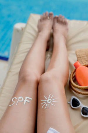 Closeup female leg with sun shape. Sun protection. Suncream, on her smooth tanned legs. Sunblockの写真素材