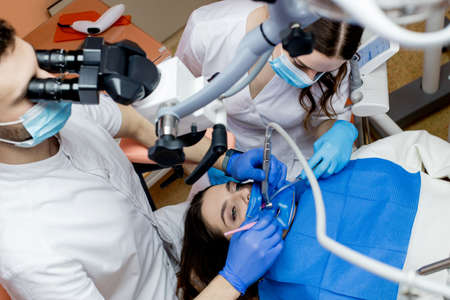 A dentist treats a woman's teeth using a cofferdam. dental equipment.の写真素材