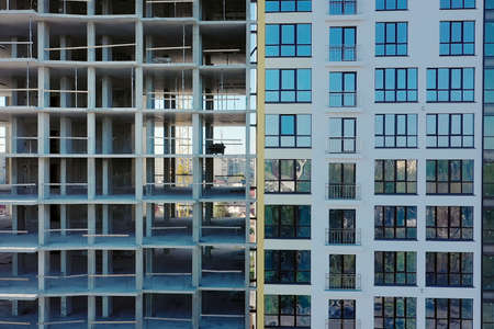 Aerial view of high residential apartment building under construction. Many windows on new apartment building facade under construction. Real estate developmentの写真素材