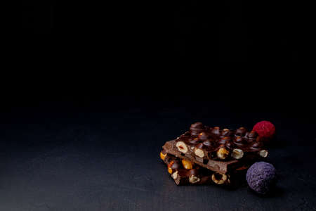 Chocolate bar, crushed pieces of dark chocolate and nuts. Praline Chocolate sweets. Copy space.の写真素材