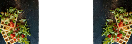 Fresh baked Belgian waffles with arugula, tomatoes and avocado on black a plate isolated on white background. Savory waffles. Breakfast concept. Healthy breakfastの写真素材