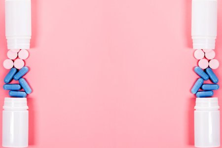 Pregnancy test with two stripes and pink and blue pills. Pastel pink color background. positive...