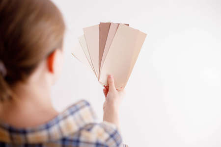 Young woman holds in her hand color paint samples for the wallの写真素材