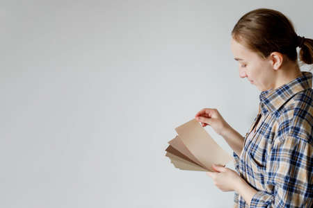 Young woman holds in her hand color paint samples for the wallの写真素材