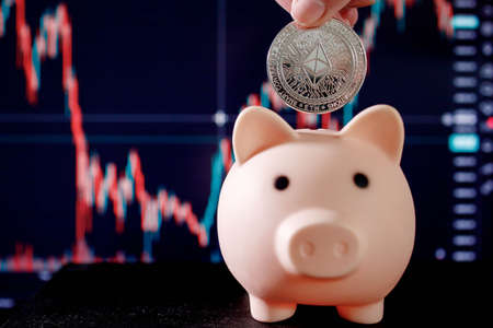 Woman tosses Ethereum into piggy bank to accumulate a budget cryptocurrency Business and Trading, Savings and Investing Digital money, Future finance concept.の写真素材