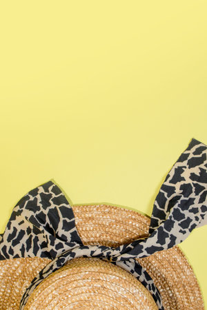 Womens summer straw hat on yellow background top view flat lay copy space.