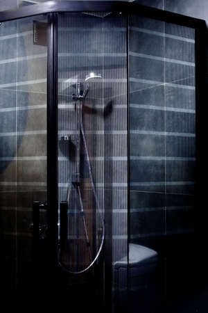 Minimalist luxury shower, fully decorated with dark gray tiles, with a rain headの写真素材