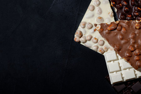Top view in section on a bar of dark chocolate with hazelnuts.