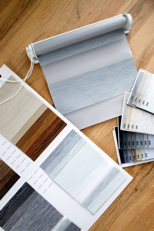 Samples of fabrics of different textures and colors in the form of a catalog for the selection of fabrics for fabric blinds. Samples of blinds day and night.の写真素材