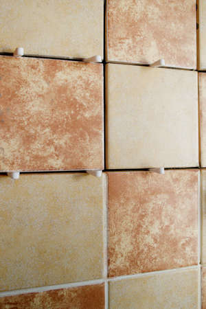 Laying ceramic tiles on a special cement mortar with the help of spacers used by tilers during wall cladding.の写真素材