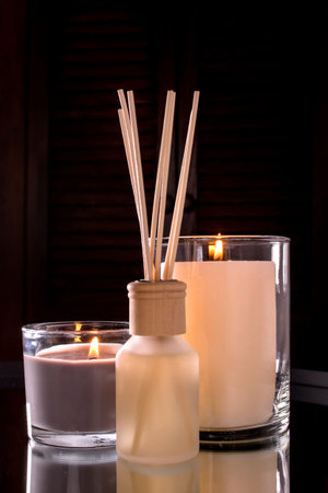 Air freshener in a glass bottle and scented candles in candle holders. home atmosphere. Fragrances...