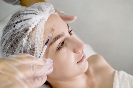 A young woman receives an injection face. youth care. Cosmetology. The beauty of the face.の写真素材