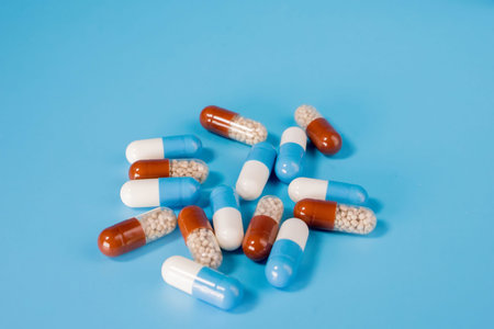 Many pills capsules on a blue background. disease treatment concept.