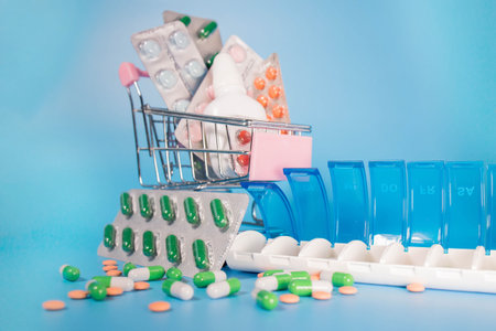 Shopping cart and pills in blister and plastic container for medicines. Concept of buying medicine online, delivery of medical devicesの写真素材