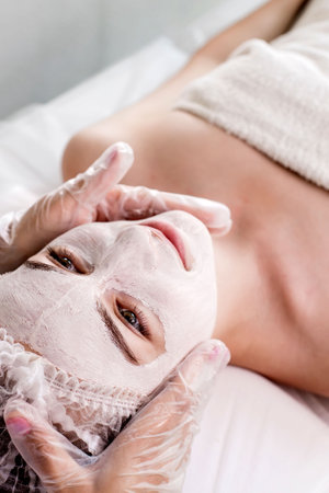 Woman in moisturizing anti-wrinkle mask. A woman is lying down, resting in a beauty salon. SPA procedures at home or in a cosmetology center.の写真素材