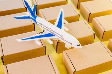 Airplane and kraft cardboard boxes. Fast delivery of goods and products. Cargo plane. Concept of air cargo and parcels, air mailの写真素材