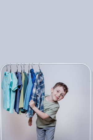 Cheerful boy peeking through clothes hanger - Joyful and Playful Childhood Moment.の写真素材