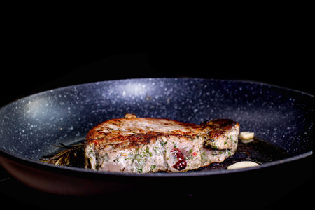 Grilled premium rib eye beef steak in the pan, cooking steak in the kitchen on a dark background....