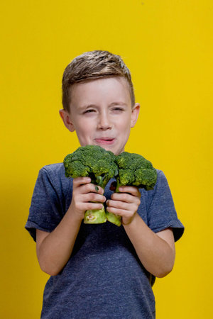 A charming little boy refusing to eat broccoli. Brootish broccoli.の写真素材