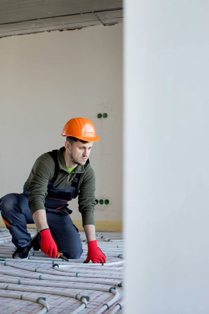 Worker is installing underfloor heating system. Warm floor heating system.