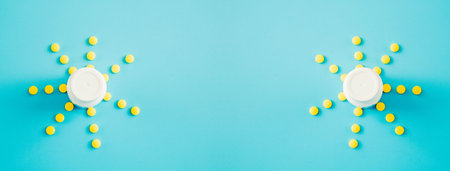 A sun of yellow pills and bottle on a blue background.
