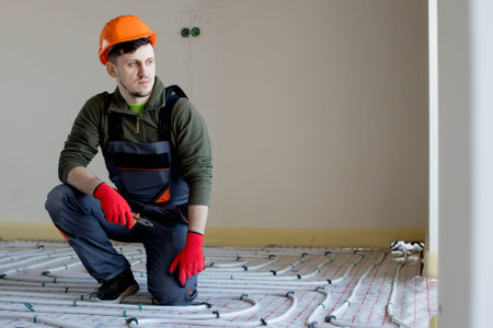 Worker is installing underfloor heating system. Warm floor heating system.の写真素材