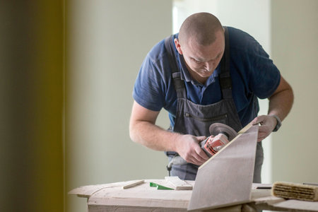 Professional tiler cutting ceramic tile for the floor or wall. Flooring and tiling