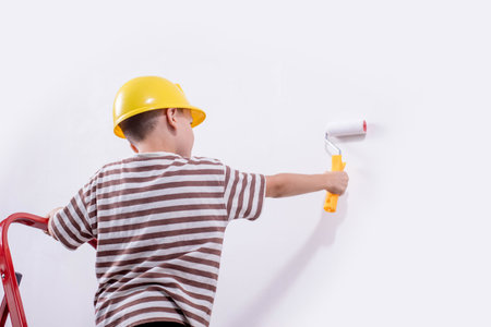 Boy painting wall during home renovationの写真素材
